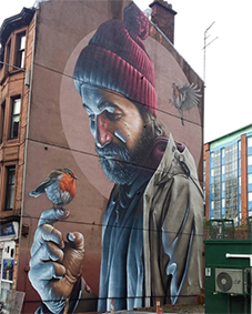 Streetart van Smug in Glasgow Muurschildering van Smug in Glasgow met man en roodborstje